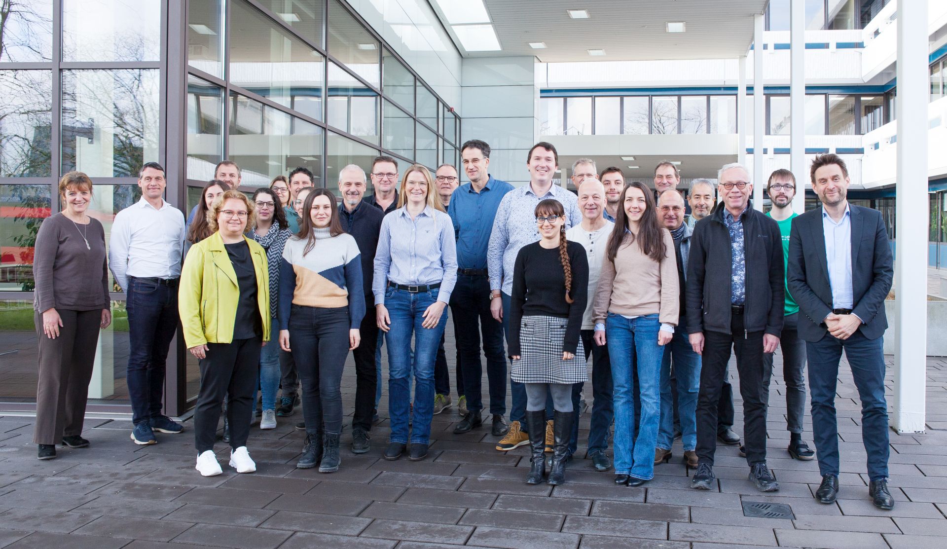 Teilnehmende am APECS-Kick-off-Meeting posieren für ein Gruppenbild vor dem Fraunhofer IAF.